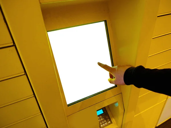 Elektronik Locker kullanarak iş adamı el closeup, sarı otomatik parsel terminali (parsel Locker, post terminali, E-Locker) mockup için boş ekran ile sokakta, ev teslim.