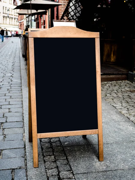 Cadre en bois vide blanc grand menu tableau noir stand pour café en plein air, restaurant dans la rue . — Photo