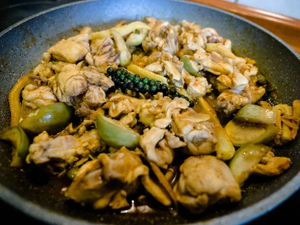 Carne de pollo salteada picante estilo tailandés casera con pimienta y chile, cocinar en una sartén en una cocina . — Foto de Stock