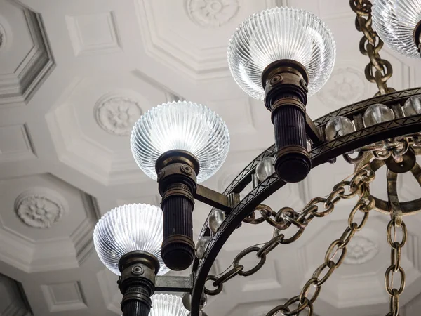 Close-up, close-up oude vintage kroonluchter met lichte kaarsen in een paleis plafond, woonkamer. — Stockfoto