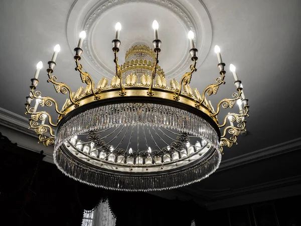 Velho lustre vintage com velas de luz em um teto do palácio, sala de estar . — Fotografia de Stock