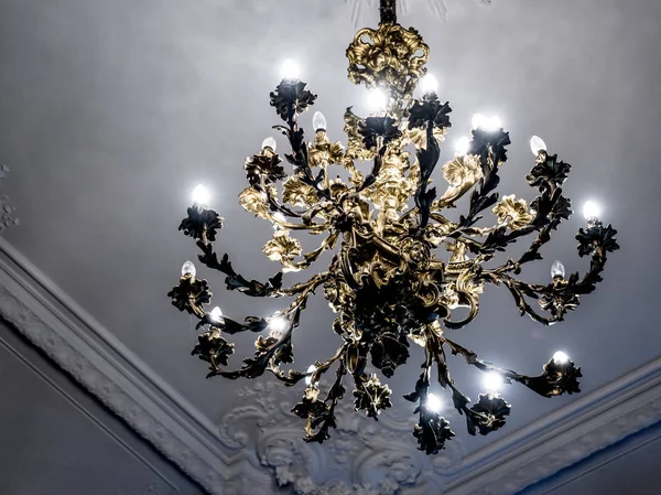 Primer plano, primer plano antigua lámpara de araña vintage con velas de luz en el techo de un palacio, sala de estar . — Foto de Stock