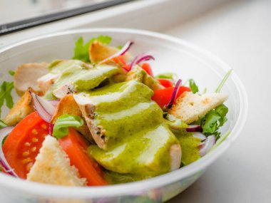 Sağlıklı basit tavuk salatası ile domates, Arugula, yeşil salata sosu ve ekmek kruton bir cam kase, vinaigrette yeşil salata tarifi için