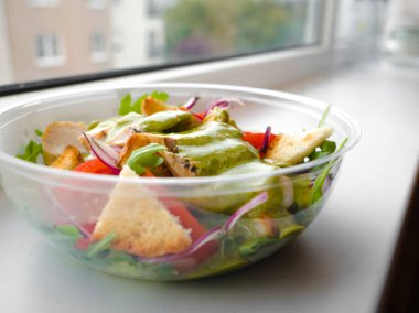 Sağlıklı basit tavuk salatası ile domates, Arugula, yeşil salata sosu ve ekmek kruton bir cam kase, vinaigrette yeşil salata tarifi için