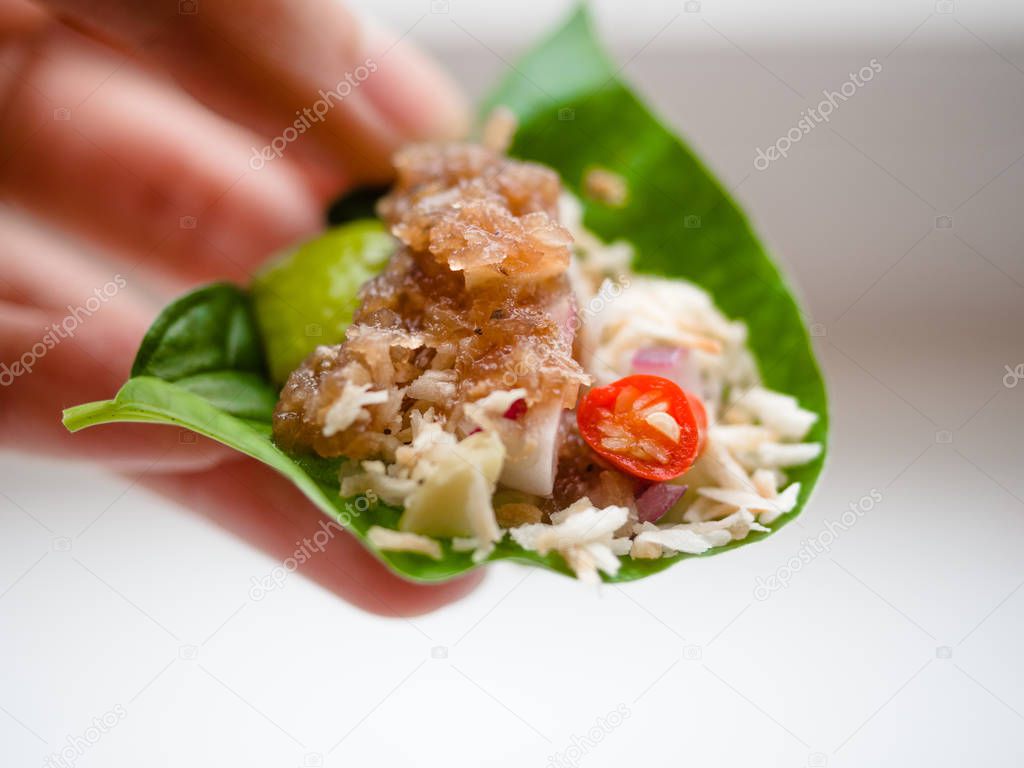 Thai-Style Savory Leaf Wraps (Miang Kham) a traditional snack from Thailand and Laos, introduced to Siamese court of King Rama V by Queen Dara Rasamee, Name Miang Kham translates to one bite wrap