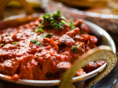 Hint Gıda veya Hint Curry bir bakır pirinç, oryantal kase hizmet, tavuk fileto içinde köri sos malzemelerle bir Pan eski masa tarafı görünümü yakın-up, Hint Gıda seti.