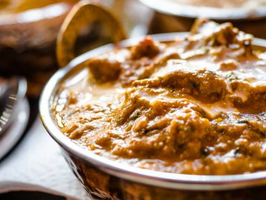 Hint Gıda veya Hint Curry bir bakır pirinç, oryantal kase hizmet, tavuk fileto içinde köri sos malzemelerle bir Pan eski masa tarafı görünümü yakın-up, Hint Gıda seti.