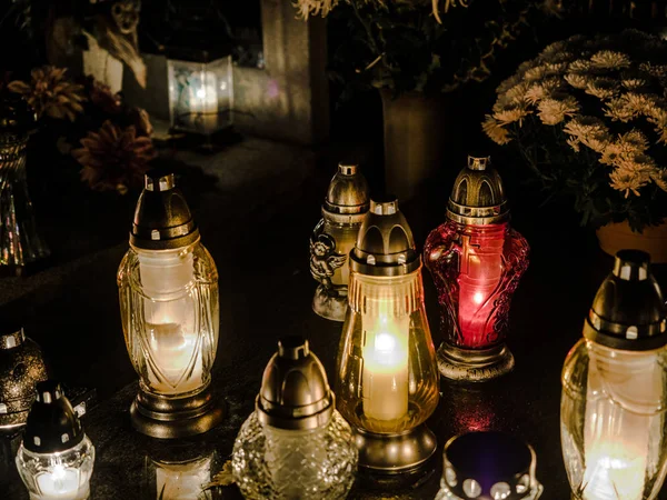 Membakar lilin berwarna-warni lampu di kuburan di malam hari. 1 November Hari Semua Orang Kudus, pemakaman tradisional Polandia pada pesta dan ruang kosong untuk teks . — Stok Foto