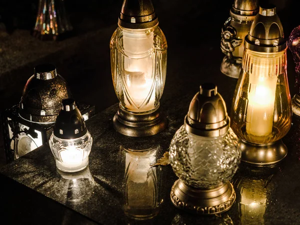 Lámpara de velas de colores ardientes en el cementerio por la noche. 1 de noviembre Día de Todos los Santos, el cementerio tradicional polaco en la fiesta y el espacio vacío para el texto . — Foto de Stock