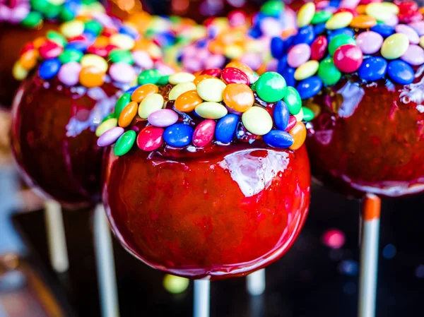 Colorful candy apples for sale at a country fair market, lovely sweet red sugar apples.