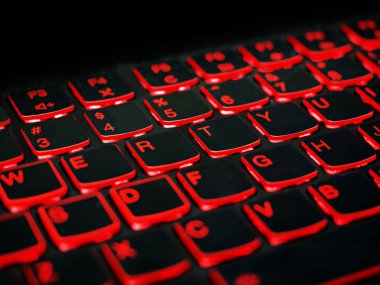 Kapat şunu. Kırmızı arka aydınlatma, karanlıkta oyun dizüstü veya klavye bilgisayarında arkadan aydınlatmalı. Karanlıkta arkadan aydınlatmalı, kırmızı koyu arka aydınlatma ile bilgisayar dizüstü klavye. Konsept bilgisayar arka planı.
