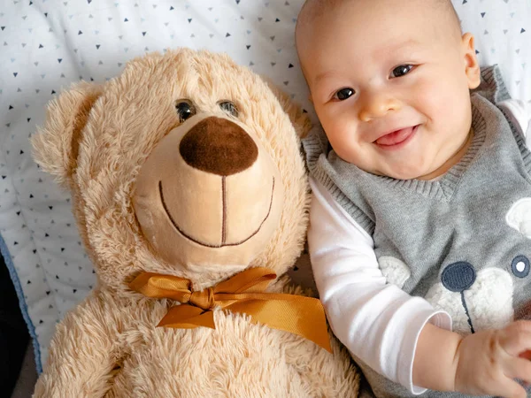 Happy baby with teddy bear Cute 4 months old mixed half race Asian Caucasian boy looking happy smiling and laughing at the camera, healthy child baby boy. Half Thai half Polish.