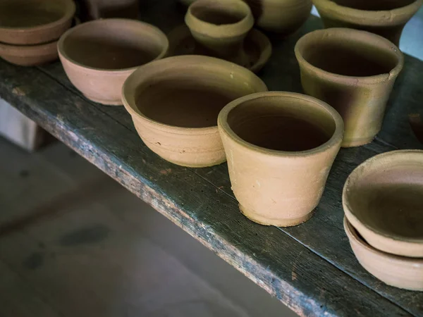 Ceramic handcraft pottery, Craftsman artist making craft, pottery, Shelves in pottery workshop full of hand crafted dishes and pots made of clay ready for glazing.