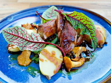 Konsept: restoran menüleri, sağlıklı yeme, ev yapımı, Gourmands, Gluttony. Beyaz plaka domuz madalyon mantar sos ile yıpranmış ahşap masada. yan görünüm, kavrulmuş domuz fileto-bonfile