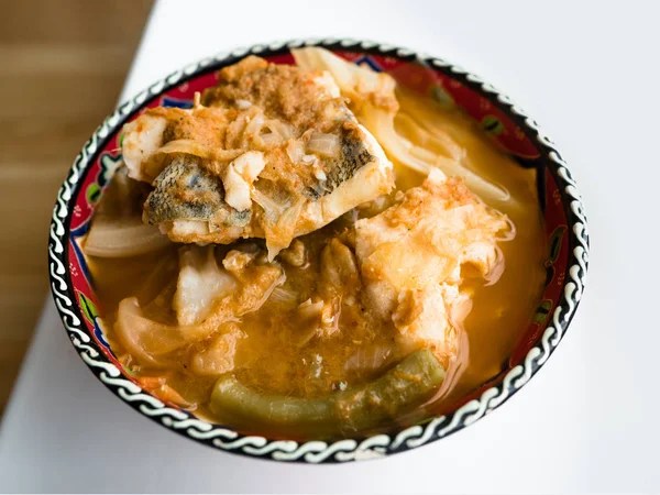 흰 테이블에 있는 아름 다운 그릇에 생선과 혼합 채소를 사용한 새 콤 수프. — 스톡 사진