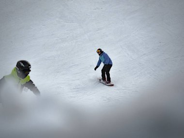 Yüksek dağlarda yokuş aşağı Skier Kayak, güneşli bir gün Snowboarder. Malta Ski, Poznan, Polonya, 25 Ocak 2019 at Kayak shot.
