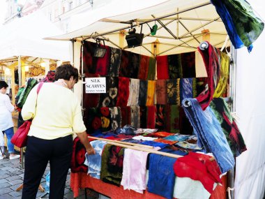 14 Nisan 2018, Poznan, Polonya, bit pazarına bakarak bir kadın, gerçek ipek eşarp Dükkanı