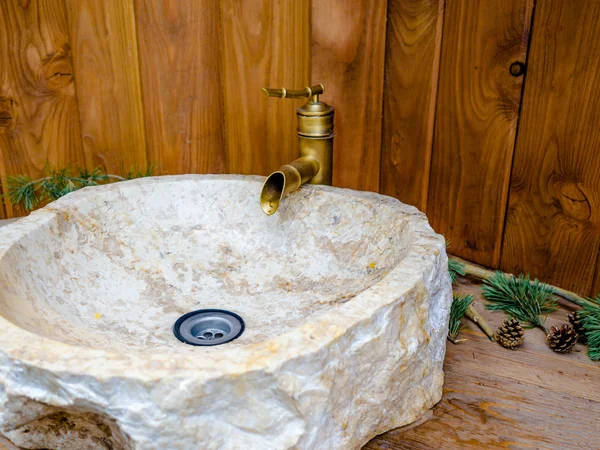 Круглая каменная раковина в современной ванной комнате с латунной водопроводной водой, красивый кран и мраморная раковина с деревянной стеной . — стоковое фото