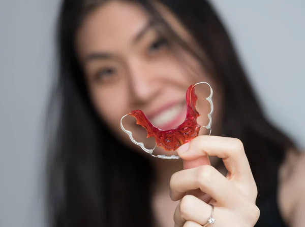 Portrait of beautiful Asian patient woman holding orthodontic retainers in dental clinic, Smiling Girl Holding blue Retainer, Braces for Teeth. Orthodontics Dental Theme, Methods of Teeth Correction — Stock Photo, Image
