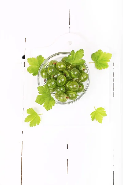 Gooseberry dengan daun pada latar belakang kayu putih — Stok Foto