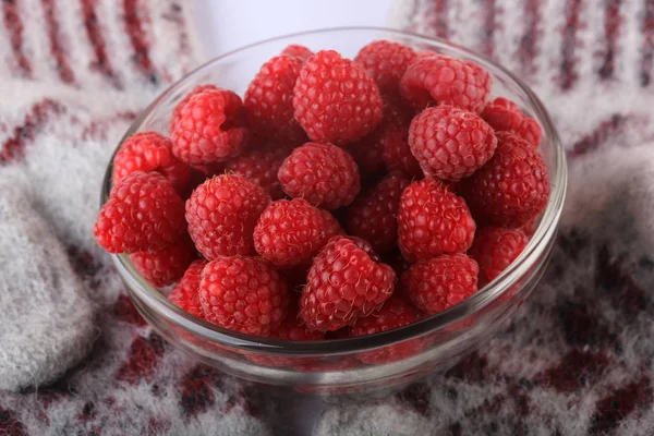 Raspberries in a glass bowl on a knitted woolen background. winter concept — Stock Photo, Image