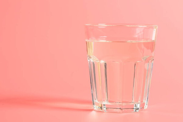 glass of water on a pink background.