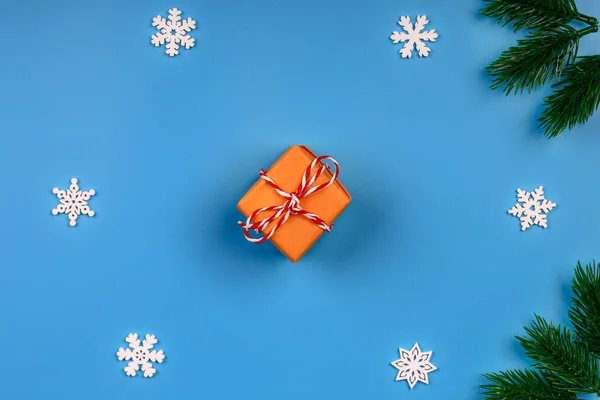 Noel arkaplanı. Hediye kutusu. Spruce şubesi. Kar taneleri. Mavi arka plan. Üst Manzara. Yakın plan..