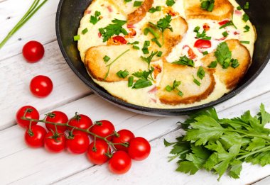 Beyaz passal arka planda domates ve maydanoz ile rustik omlet kahvaltı