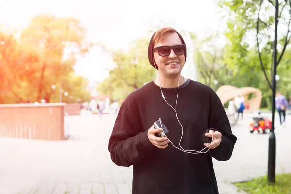 Smiling man with headphones listening to music on the street