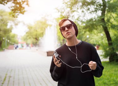 Sokakta müzik dinleyen kulaklıklı adam