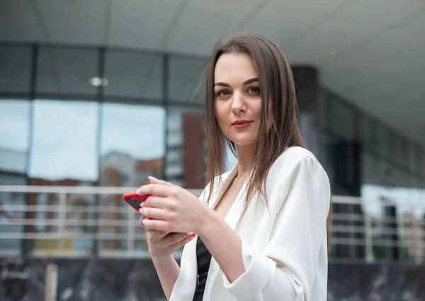 Schöne Mädchen Sieht Einem Smartphone Auf Einem Stadthintergrund — Stockfoto