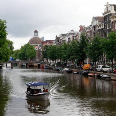 Hollanda 'da Amsterdam kanalda insanlarla tekne 