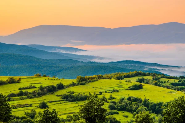 Prado Verde Brilhante Fundo Montanhas Nevoeiro Nascer Sol Início Dia — Fotografia de Stock