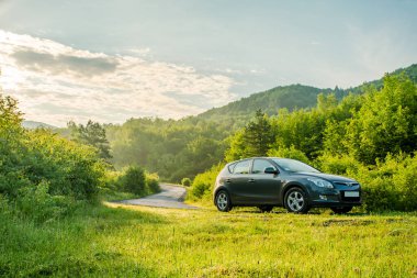 VILSHINKI, UKRAINE - JUNE 10, 2020: Hyundai i 30 hatchback car on a country road in the foggy mountains. beautiful transport landscape at sunrise in summer. travel by car concept clipart