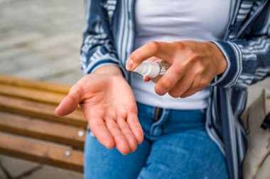 Kız ellerine antiseptik sıçratıyor. Koronavirüse karşı koruma.