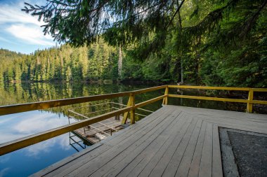Yüksek irtifa gölü Synevir. Mavi gökyüzü berrak su yeşil orman.