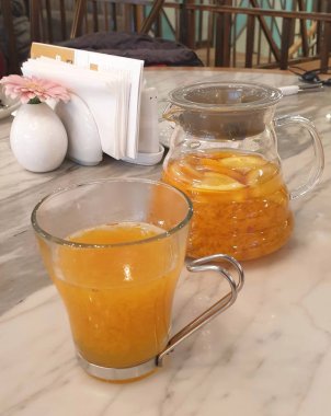 Sürahi ve bardak masanın üzerine portakal suyu ile