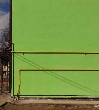 parlak yeşil duvar ve sarı borular