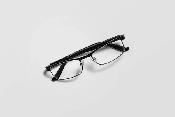 Black glasses isolated on soft gray background.