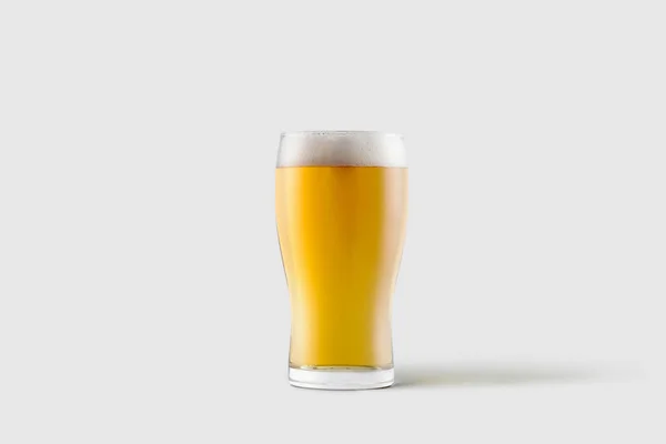 在柔软的灰色背景上分离泡沫的轻质啤酒冷杯 — 图库照片