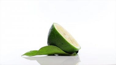 Beyaz bir masada kireç dilimi, 360 derece dönüş. Beyaz arka plan. Ultra yüksek çözünürlüklü 3840x2160.4k çözünürlük