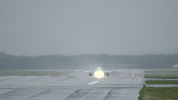 Verkehrsflugzeug beschleunigt auf nasser Piste und hebt ab — Stockvideo