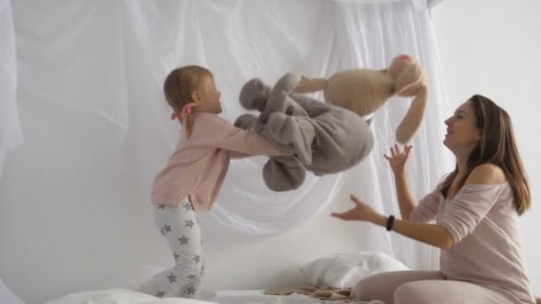 Madre e hija juegan con juguetes de peluche — Vídeo de stock