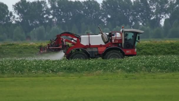 Сільськогосподарський обприскувач Tractor їде на полі — стокове відео