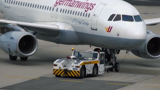 Ciągnik, spychając Airbus A319 w Dusseldorf Lotnisko — Wideo stockowe