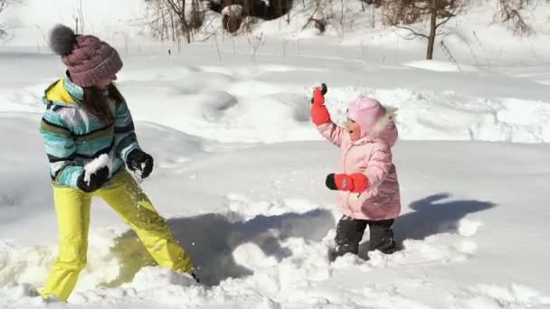 Mujer y niña lanzando nieve — Vídeo de stock