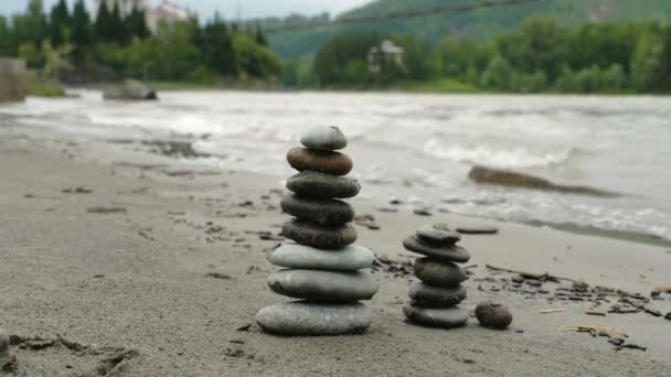 Pequeñas torres de piedras redondas en la playa — Vídeo de stock