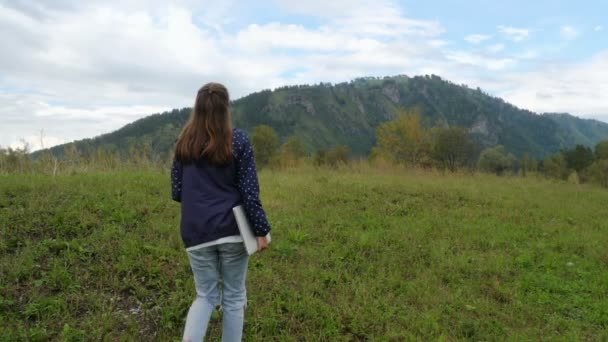 Chica está caminando con el ordenador portátil en alta montaña — Vídeo de stock