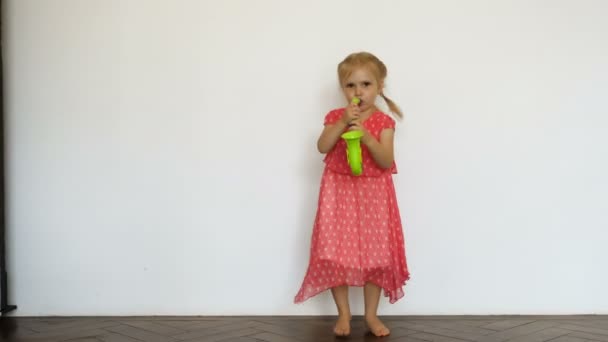 Pequena menina encantadora jogando saxofone brinquedo — Vídeo de Stock