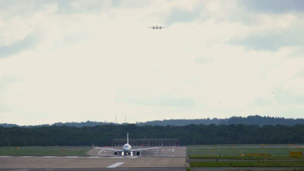 Düsenflugzeuge heben ab. Geschäftsflugzeug nähert sich derselben Landebahn — Stockvideo